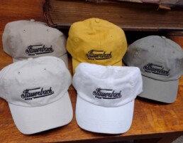 5 different colors of Fauerbach Brewing hats organized on a table.