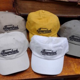 5 different colors of Fauerbach Brewing hats organized on a table.